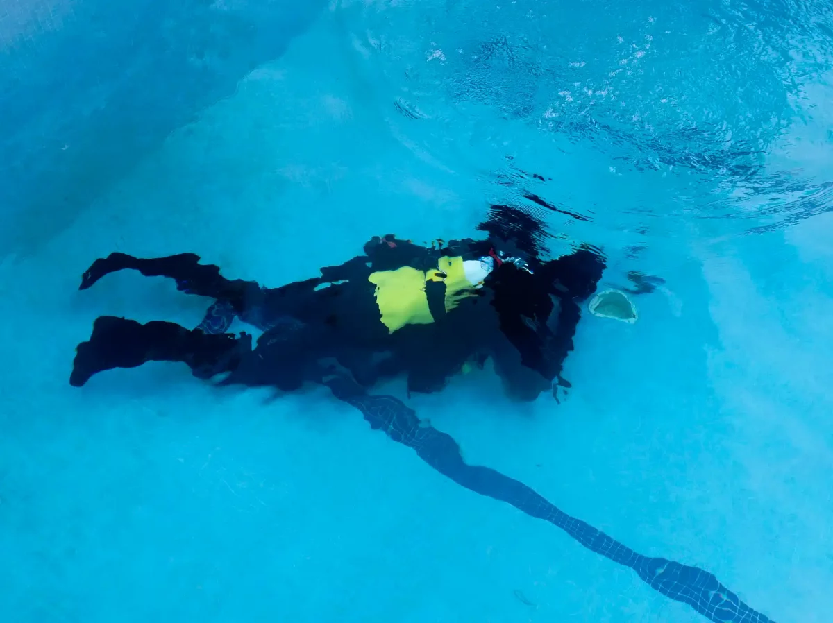 Buzo buscando fuga en fondo de piscina