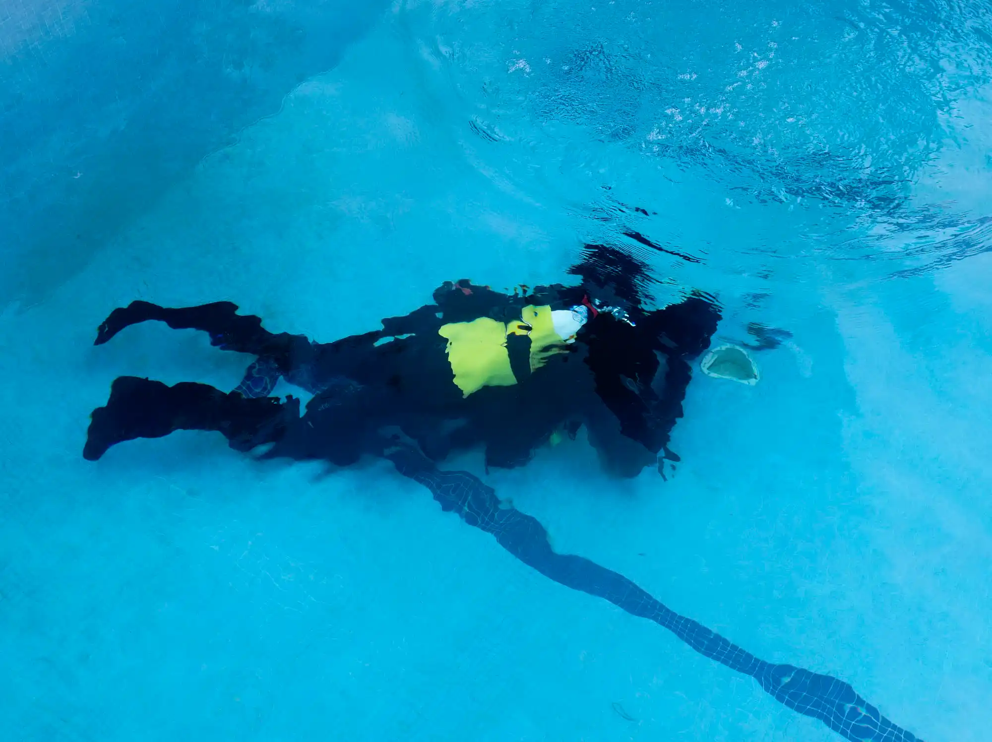 Buzo buscando fuga en fondo de piscina